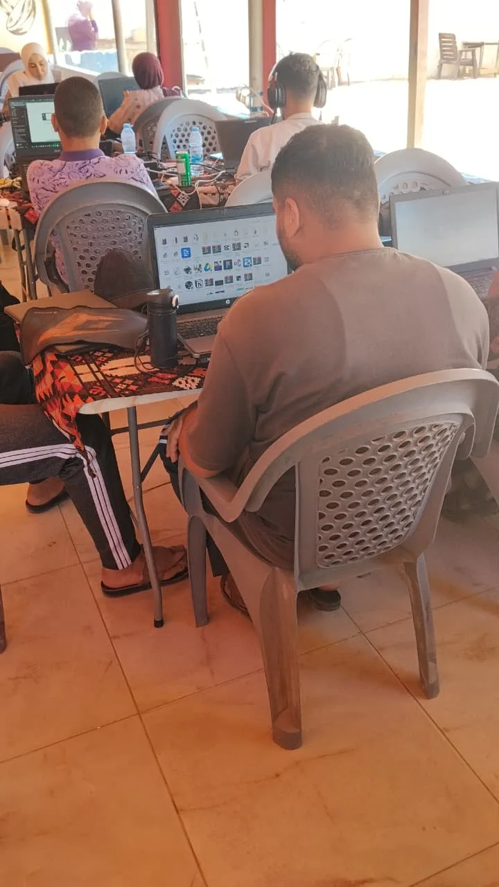 Students clustered closely together in the shaded part of the workspace